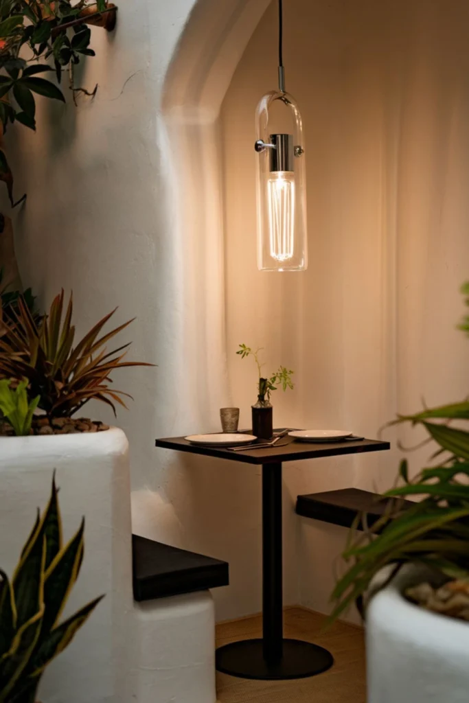 Pendant lights above a small dining table.